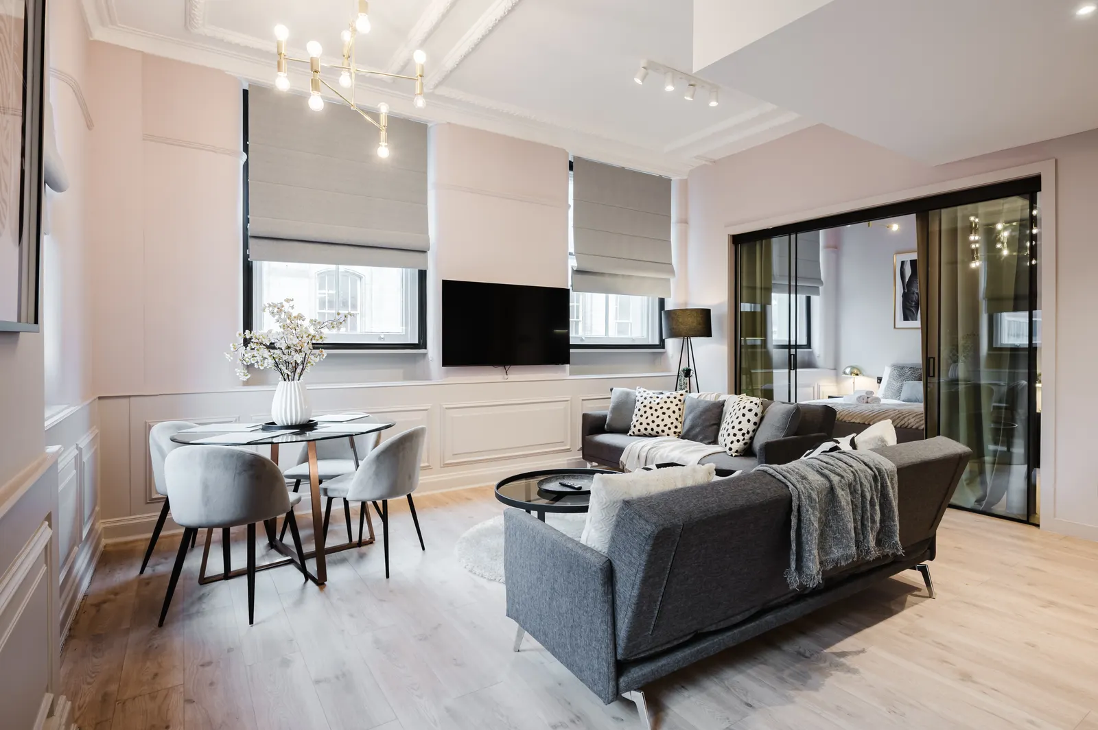 Central Manchester serviced apartment designer lounge with blush walls and gold chandelier